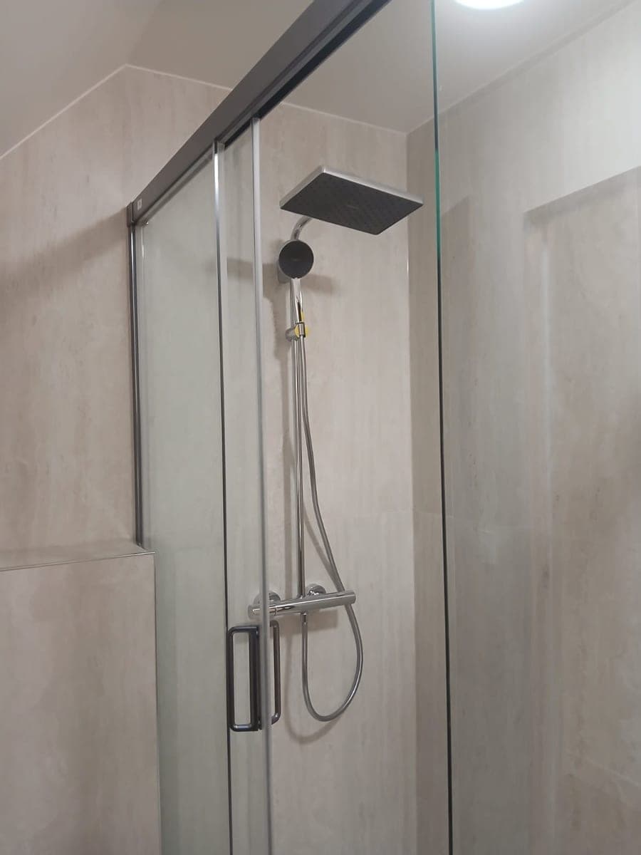 Douche à l'italienne, paroi vitrée transparente et colonne de douche chromée