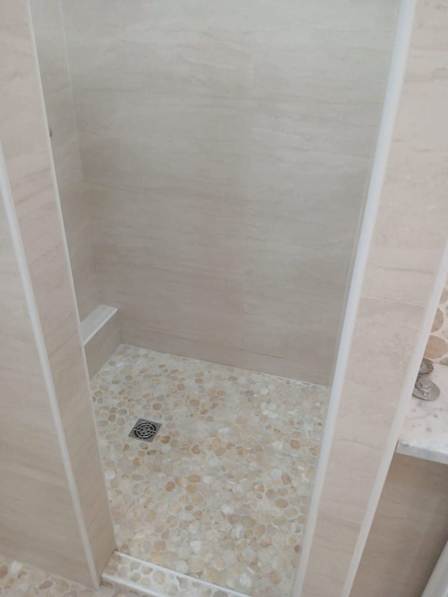 Receveur de douche en galets, bonde inox et faïence beige nettes