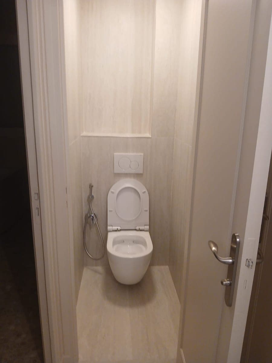WC suspendu blanc dans un habillage de faïence beige