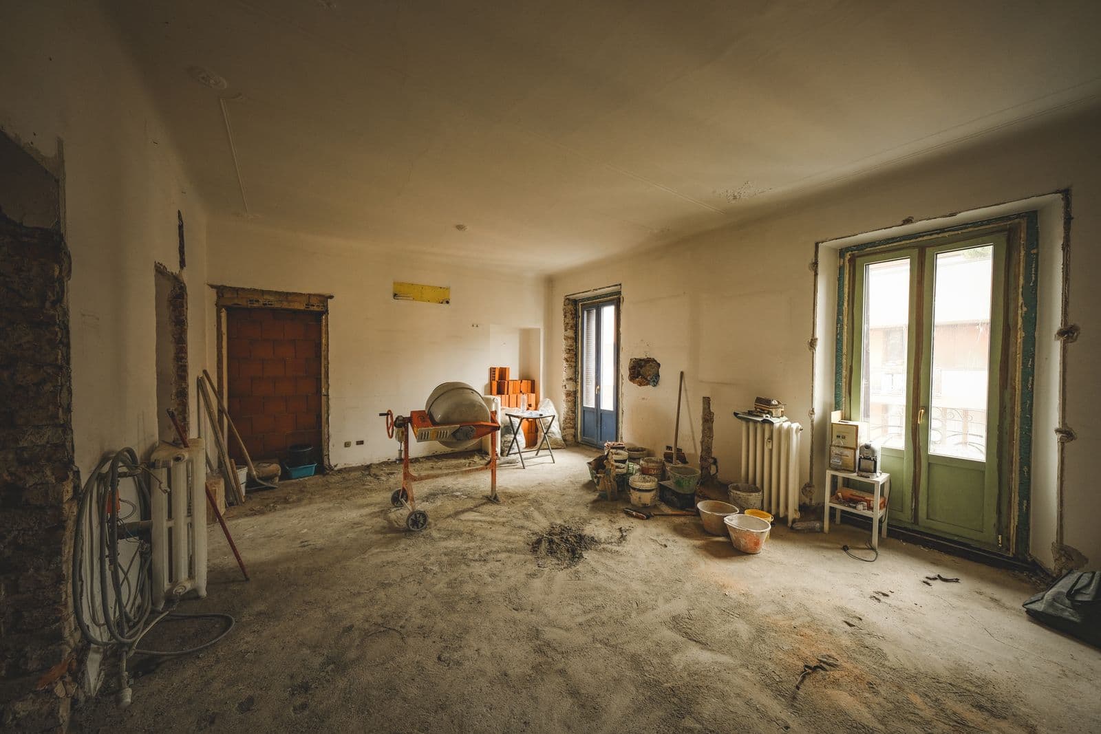 Pièce en rénovation, bétonnière et poussière de chantier