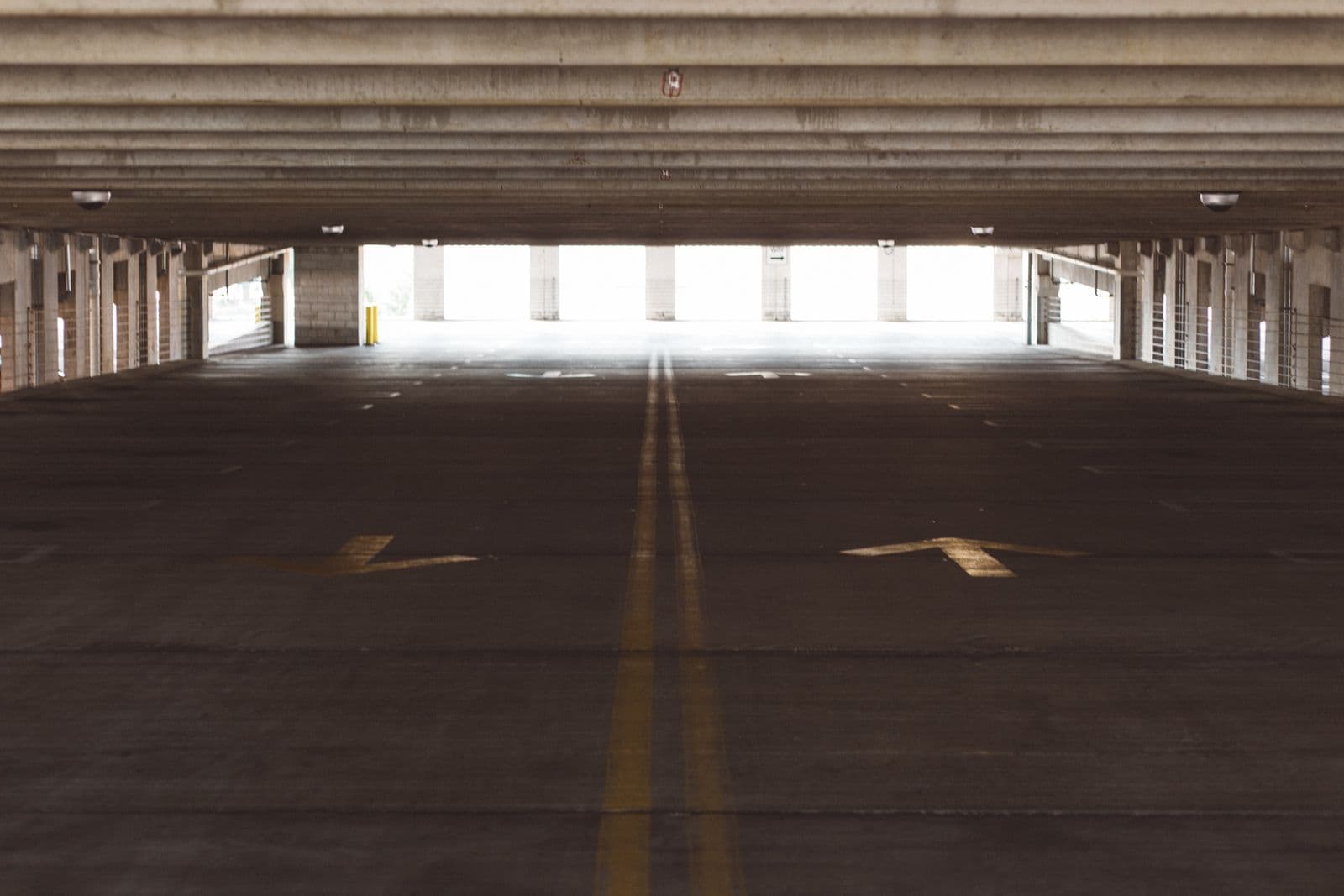 Travée de parking couvert au sol marqué par le passage