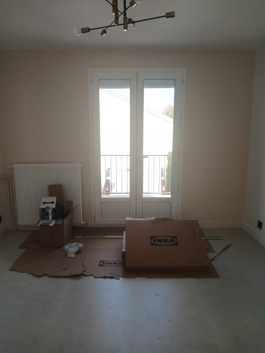 Pièce en cours d'aménagement, cartons de meubles posés sur des protections au sol