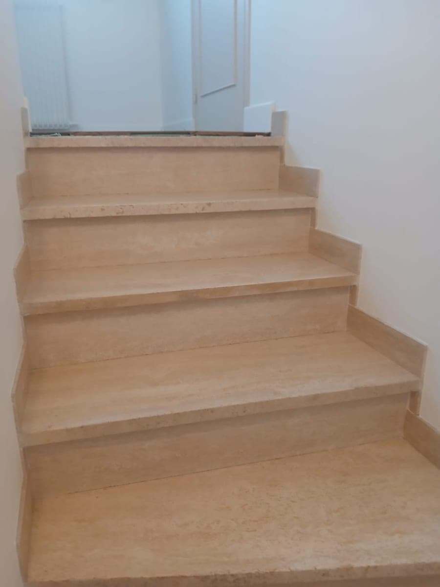 Escalier aux marches beiges montant vers l'étage, nez de marche propres