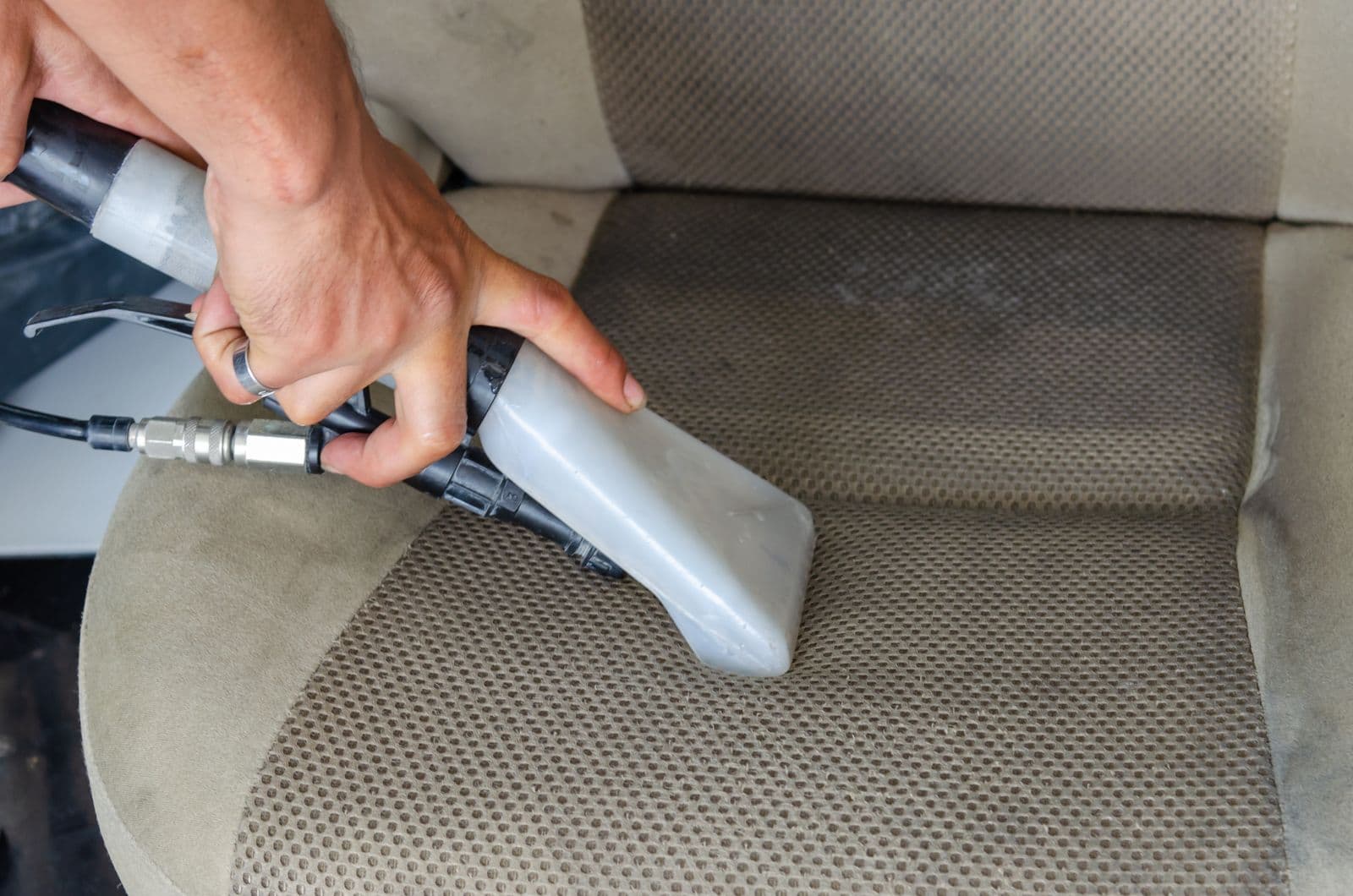Buse d'extraction nettoyant un siège de voiture en tissu